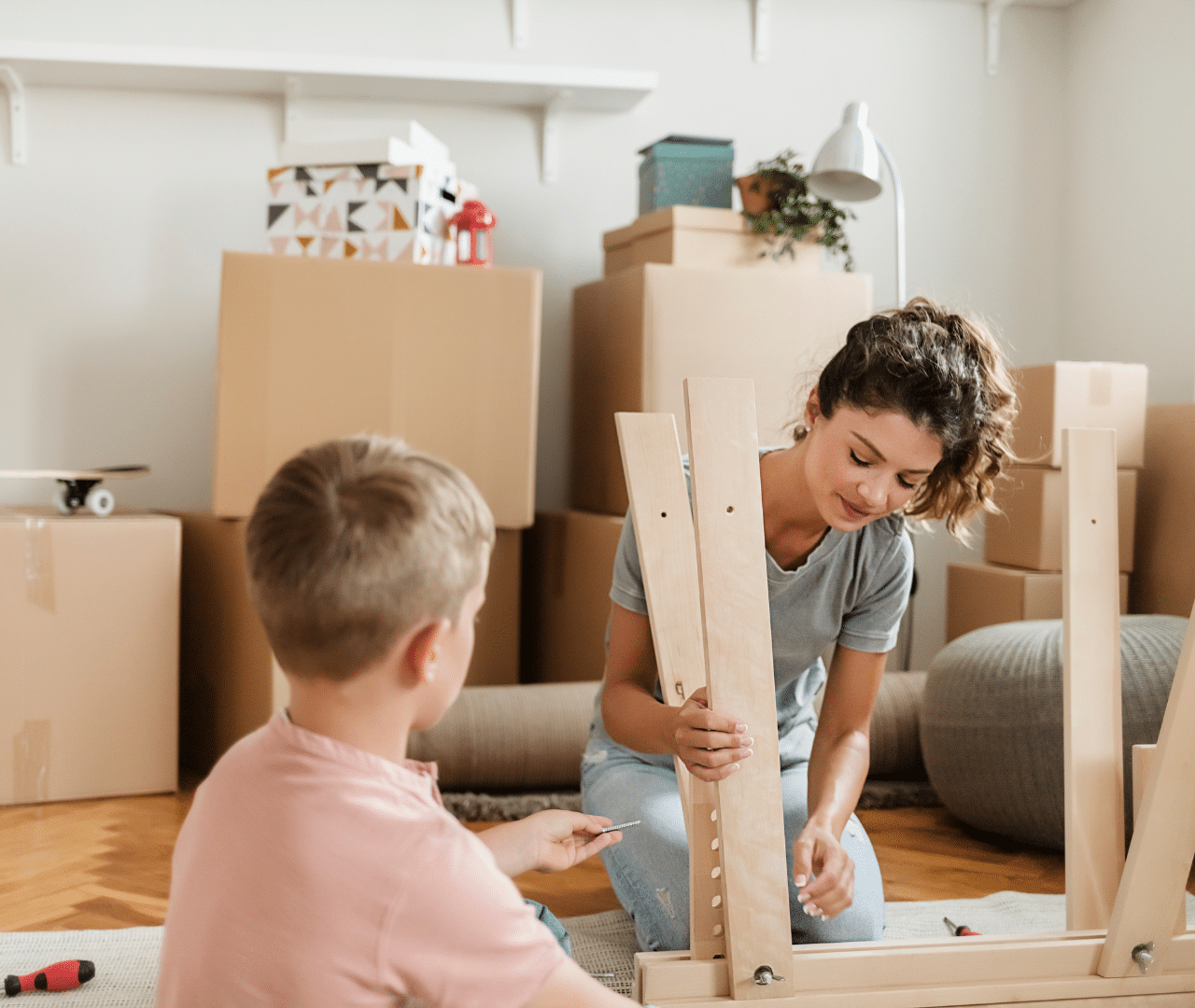 אישה מרכיבה רהיט על שטיח ובנה לידה