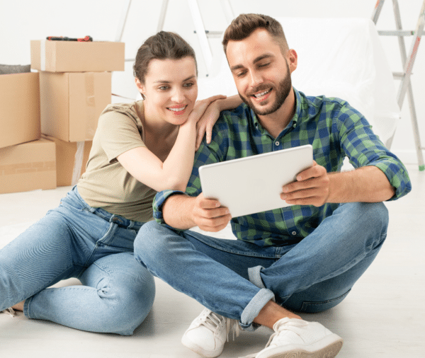 זוג יושב על הרצפה ומעיין בטאבלט